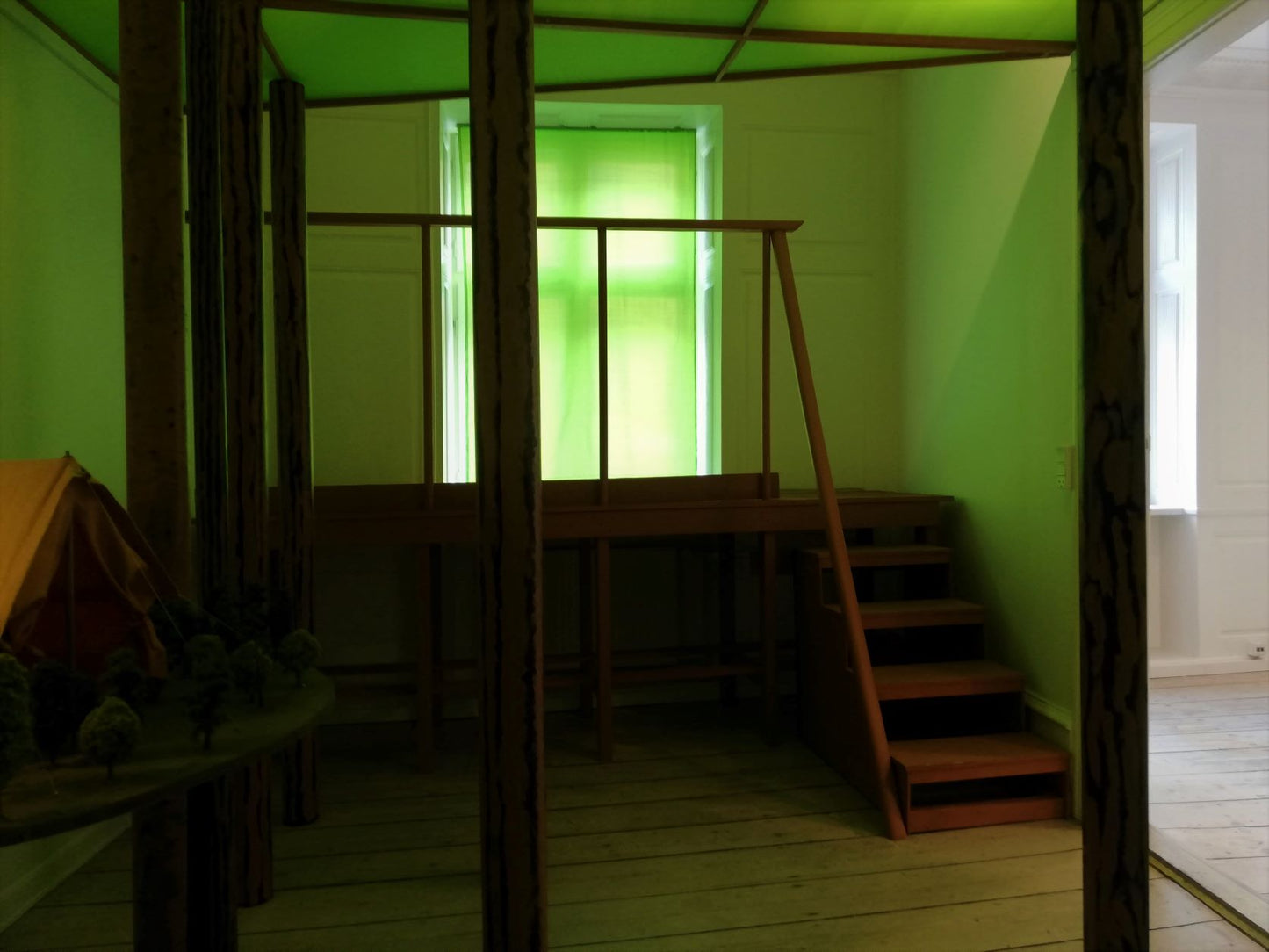 “Ventesals-maleri – Installation til galleriets sidste stue” 2022. Træ, lister, stof, skumgummi, papir og arvede modeljernbanetræer.