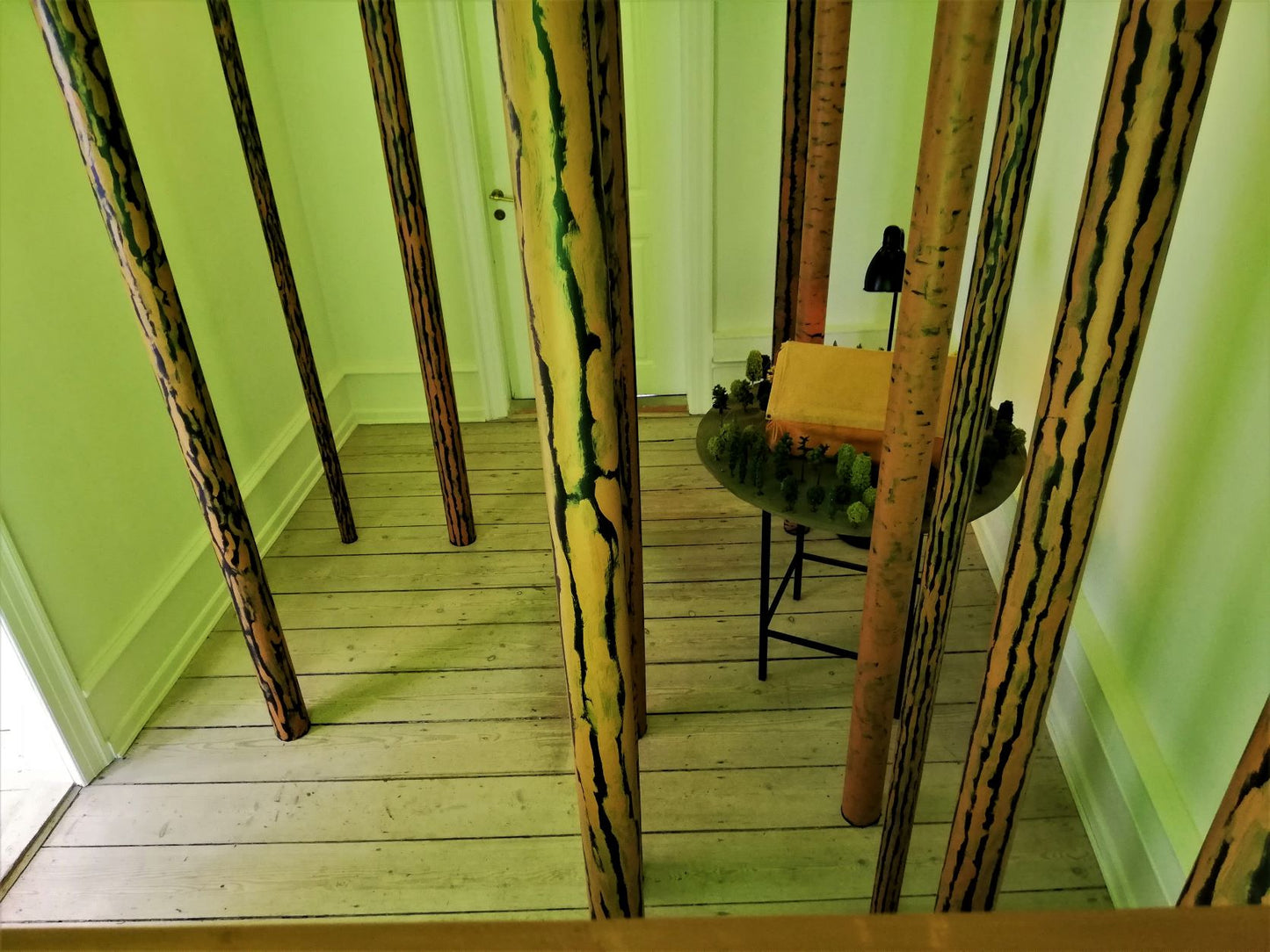 “Ventesals-maleri – Installation til galleriets sidste stue” 2022. Træ, lister, stof, skumgummi, papir og arvede modeljernbanetræer.